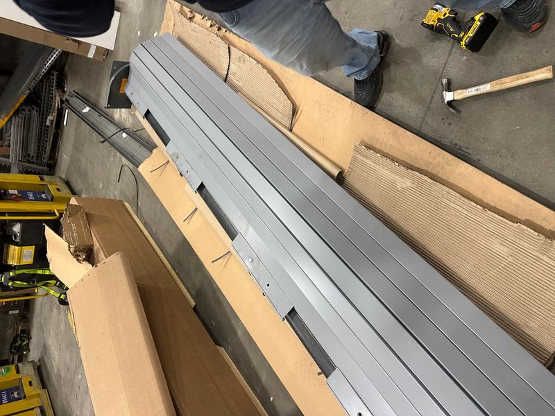 Garage door track pieces and hardware laid out for commercial installation
